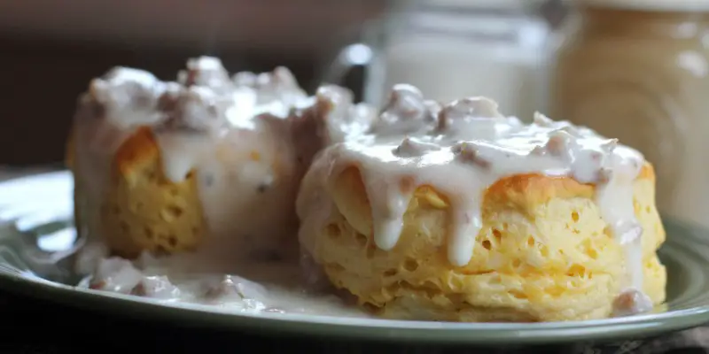 Biscuits covered in sausage gravy on a plate.